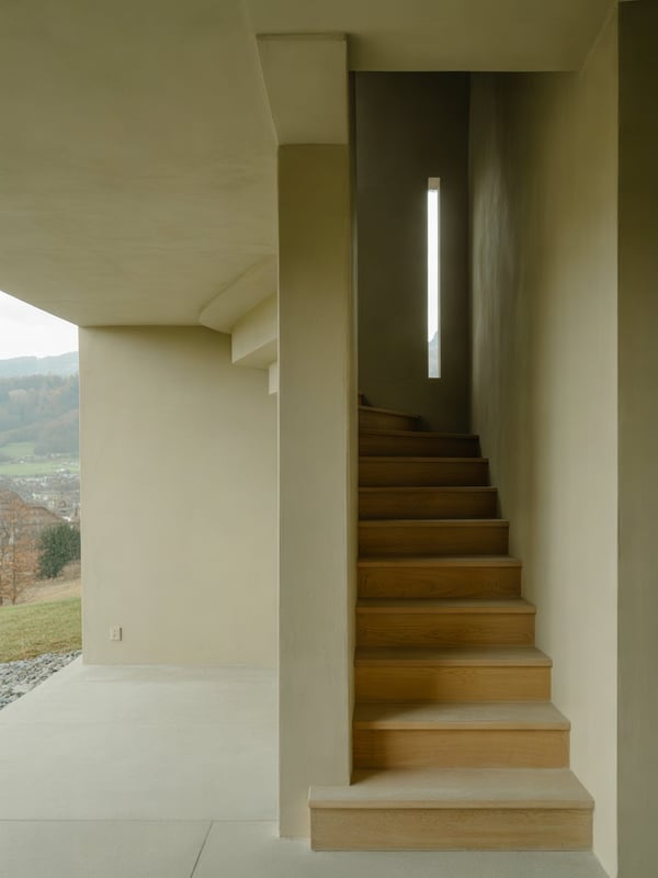 Treppendetail aus Eichenholz an einer Kalkputzwand im Tageslicht